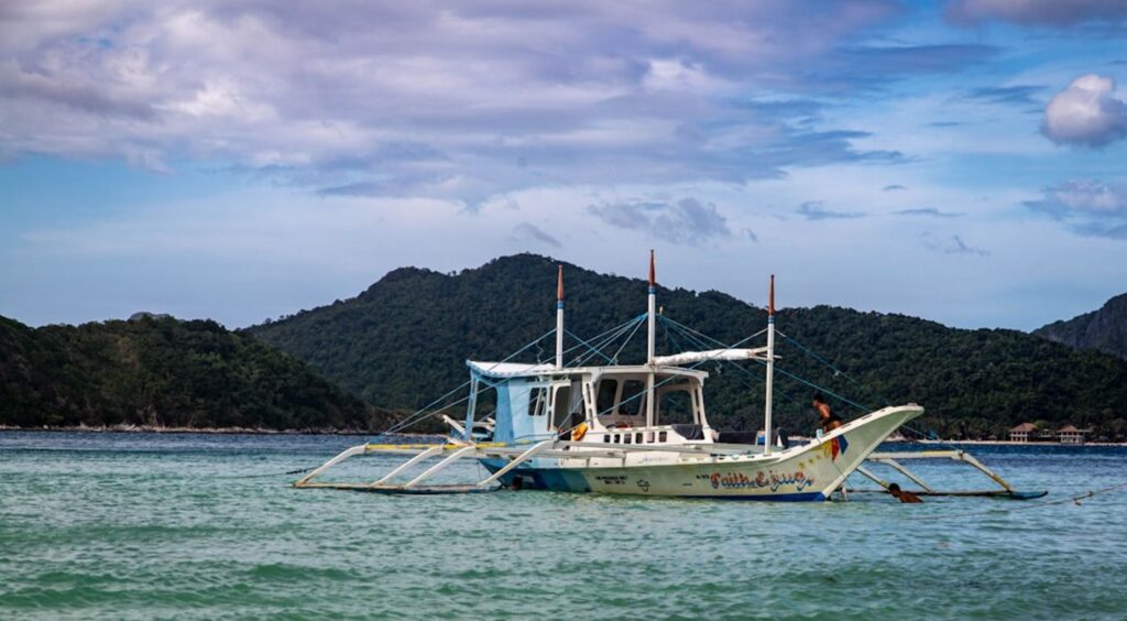 A boat floats calmly on the water.-Cat Ba Island Vietnam
