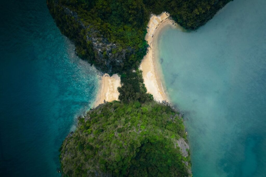 Sandy beaches connect two lush, green islands.-Derawan Islands Indonesia