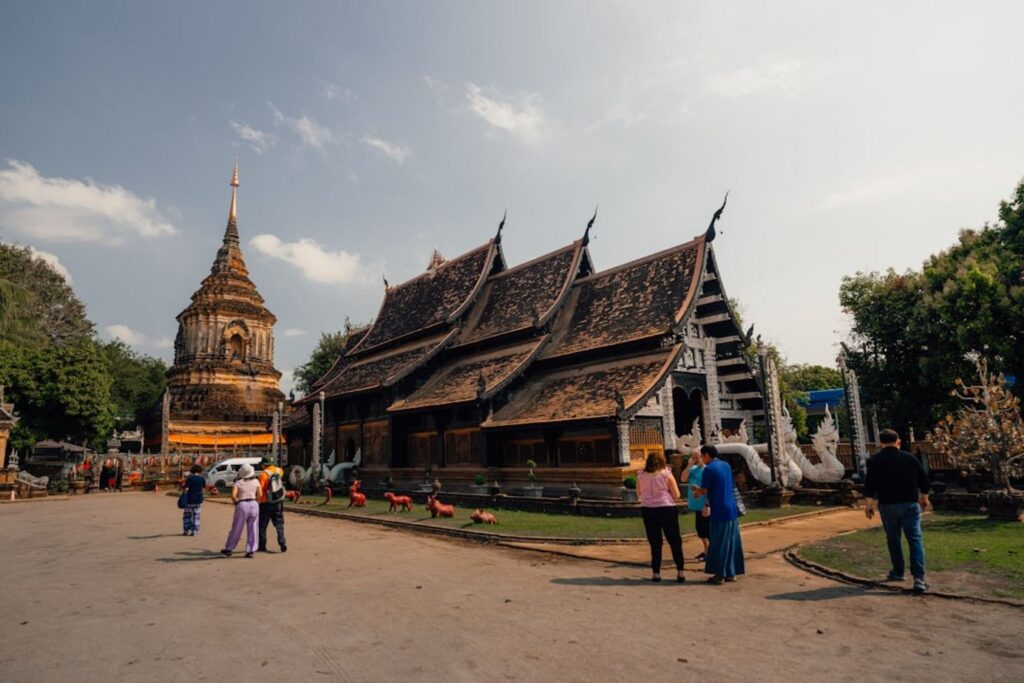 An ornate temple with people milling about.-Don Som Laos