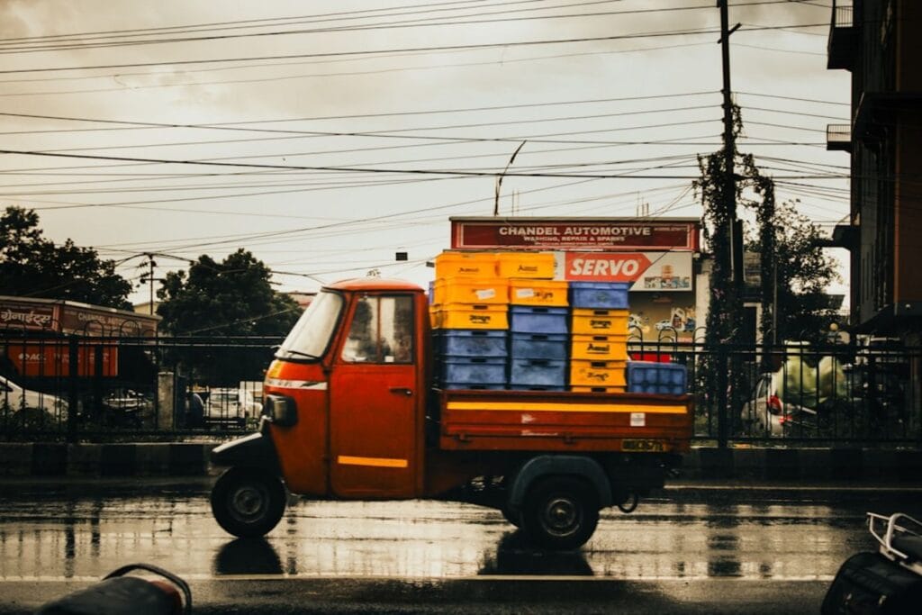 A red tuk-tuk transports crates on a wet street.-El Nido philippines weather
