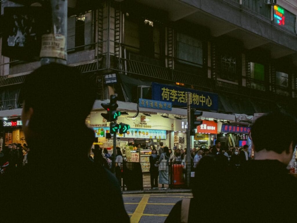 People gather at a busy, illuminated street corner.-Incheon South Korea