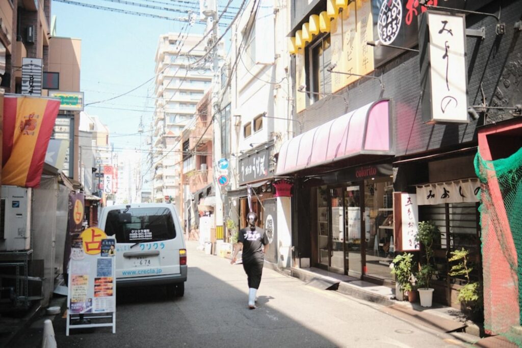 Woman walking down a narrow street with buildings.-Boseong South Korea