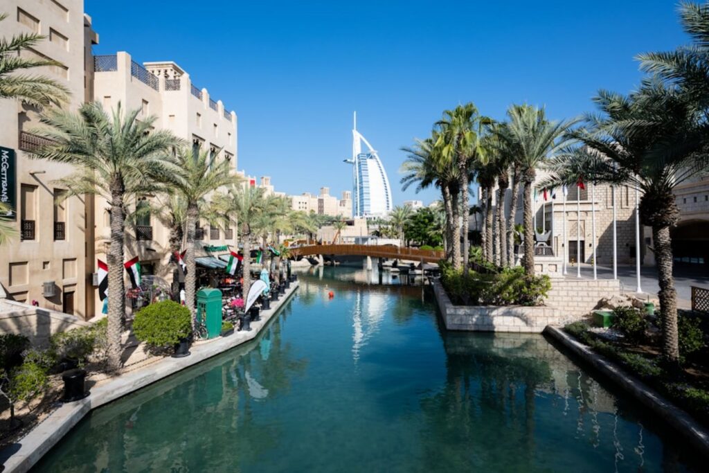 Canal with buildings and palm trees under blue sky-Dubai Marina United Arab Emirates