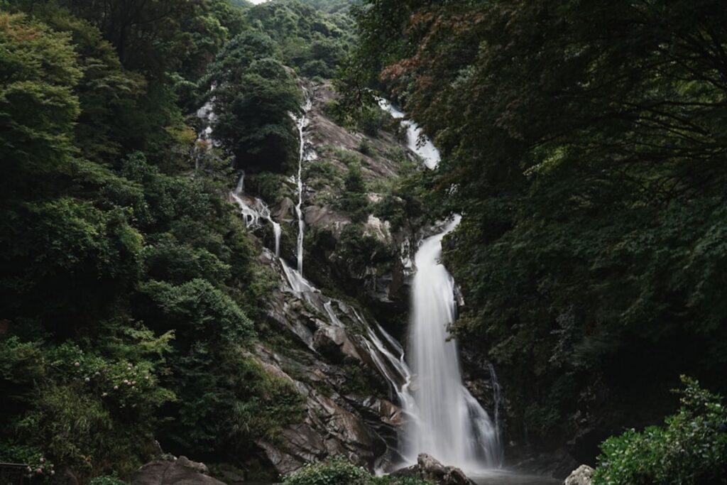 A tall waterfall cascades down a rocky mountainside.-south korea waterfall