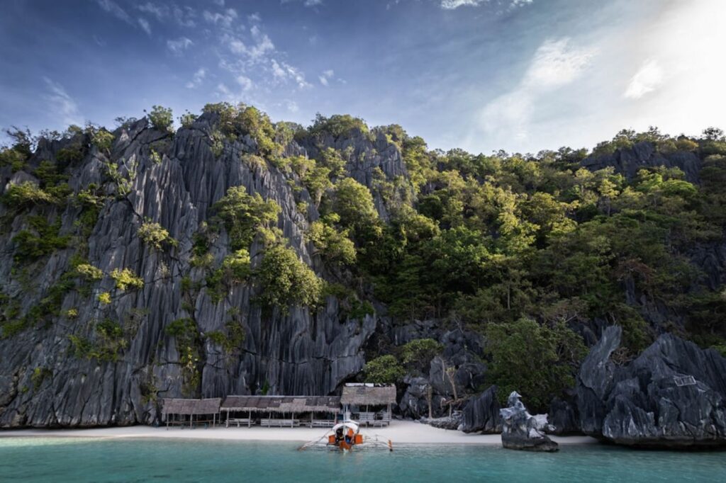 Tropical island with rocky cliffs and small huts-philippines jungle