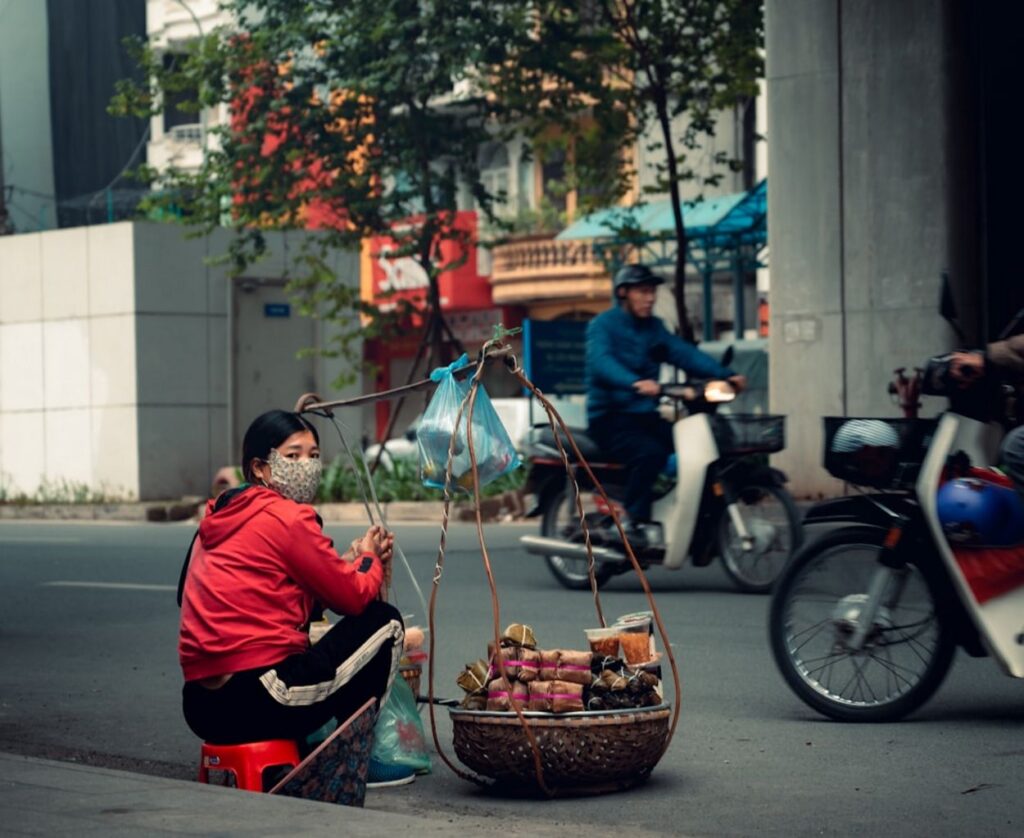 Woman wearing mask selling fruit on street-vietnam
