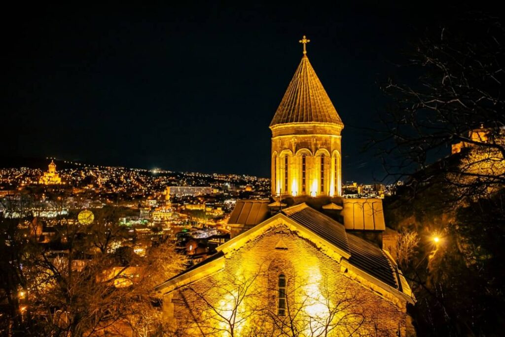 Yerevan Tbilisi-a-church-with-a-steeple-lit-up-at-night-eafuyo6cx6i